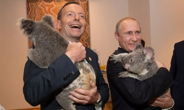 Tony Abbott and Vladimir Putin holding koalas at a public event.